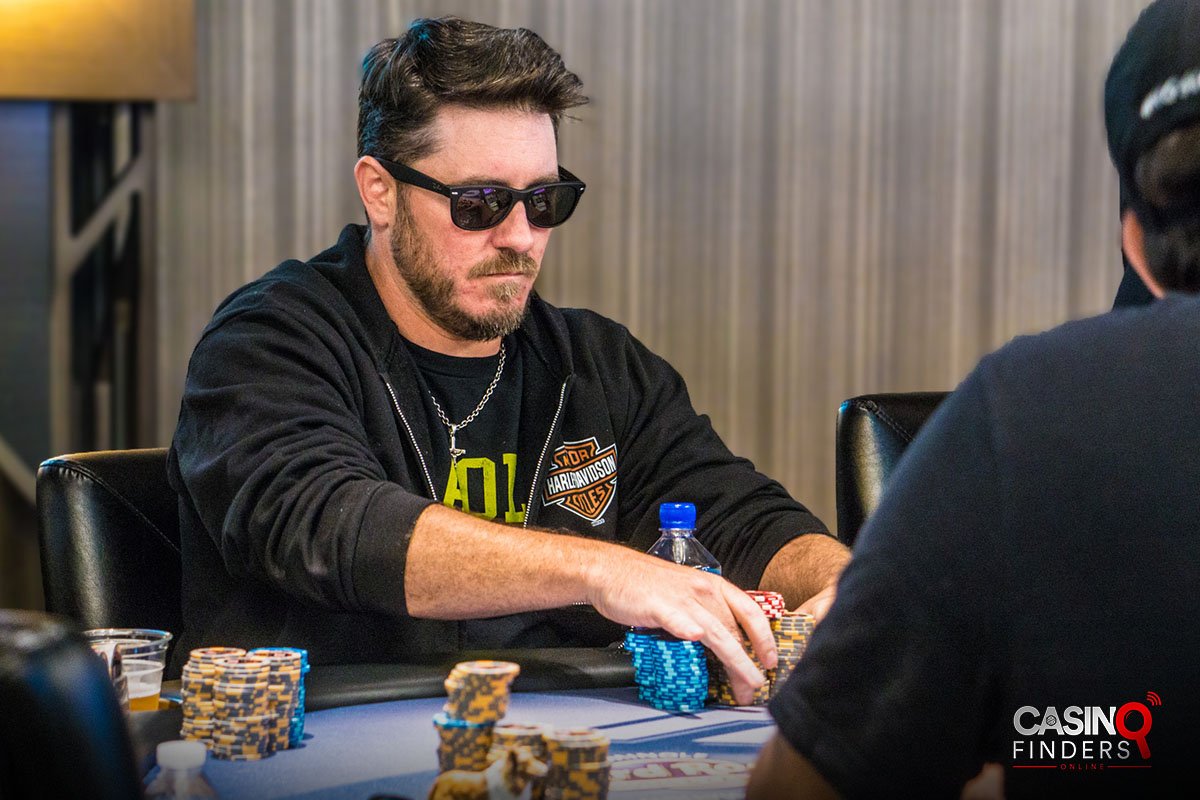 a male poker player wearing a black sunglass at a live poker table