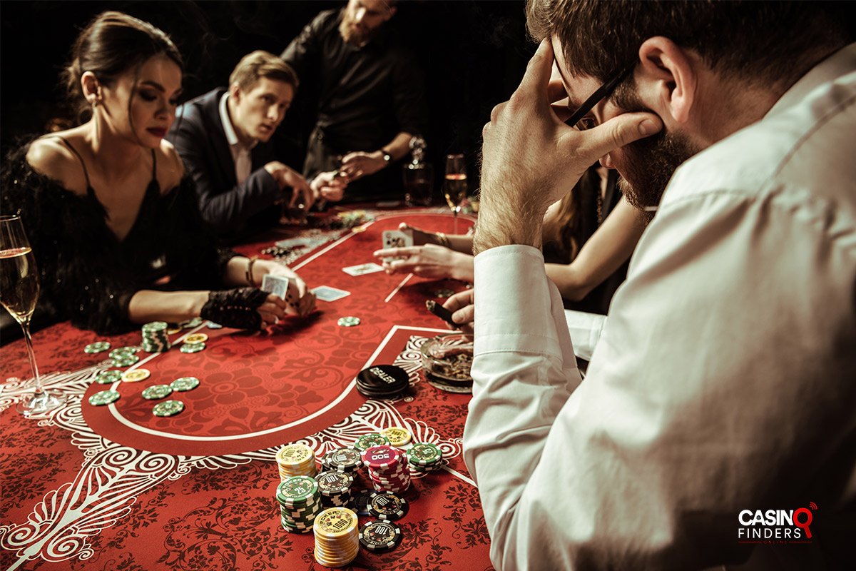concentrated men and women playing poker in casino